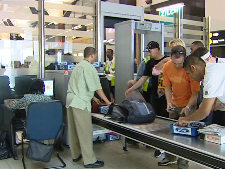 Personas en control de aeropuerto mostrando su equipaje - Viajar en avión por primera vez